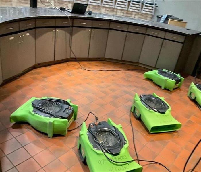 air movers drying floor, bar nearby