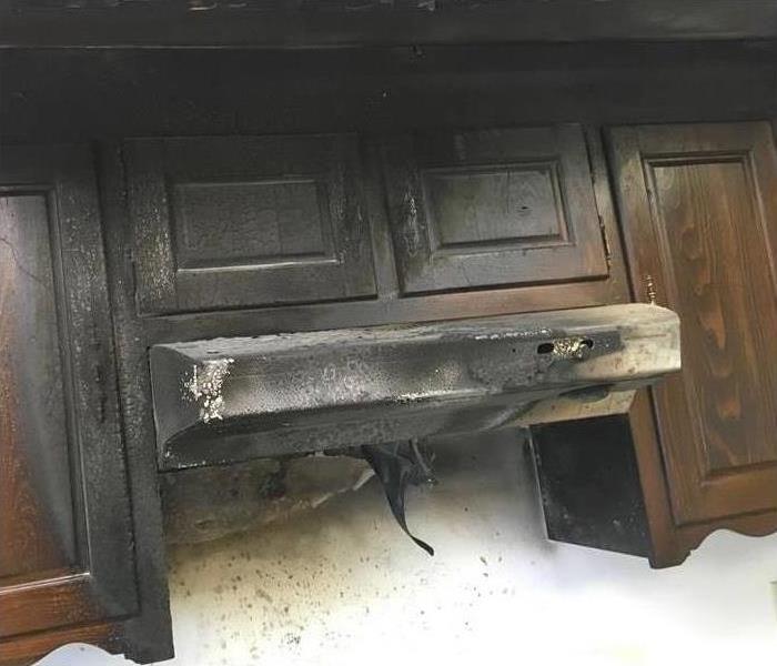 burned exhaust hood and brown upper cabinets